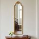 Narrow and tall antique mirror, adorned with golden patterns.