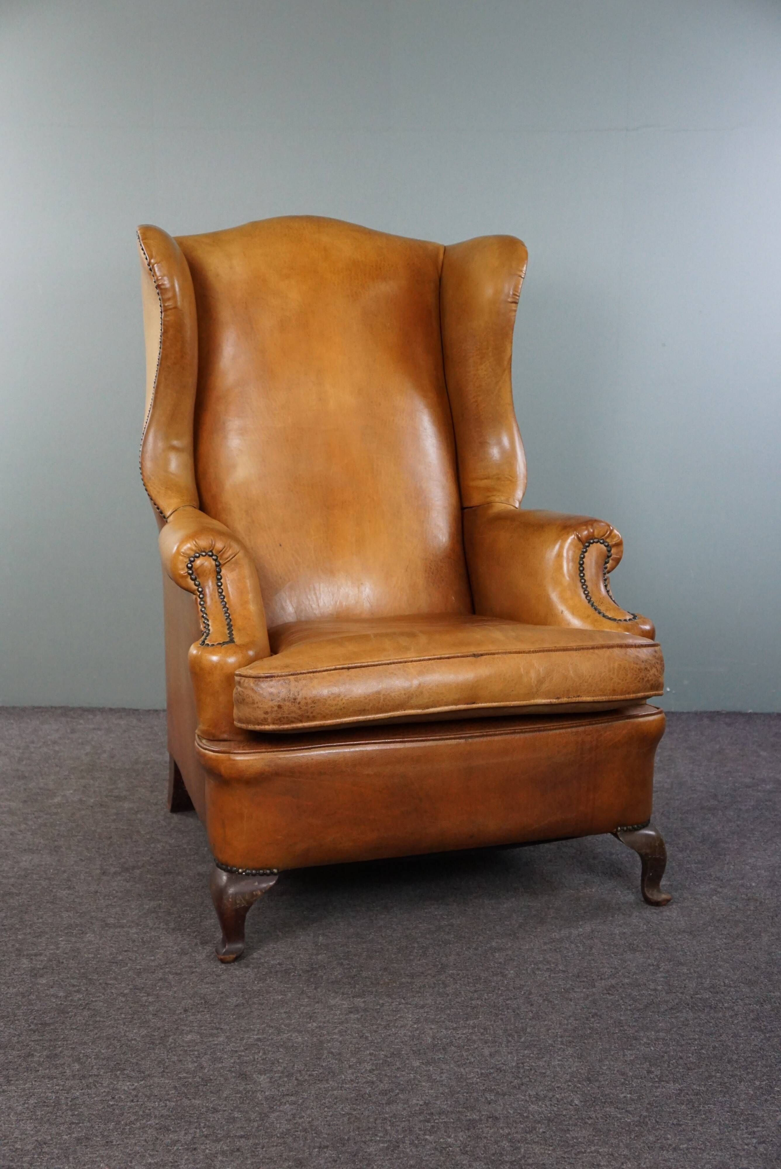 Old wingback armchair made of sheep leather in a correct condition