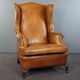 Old wingback armchair made of sheep leather in a correct condition