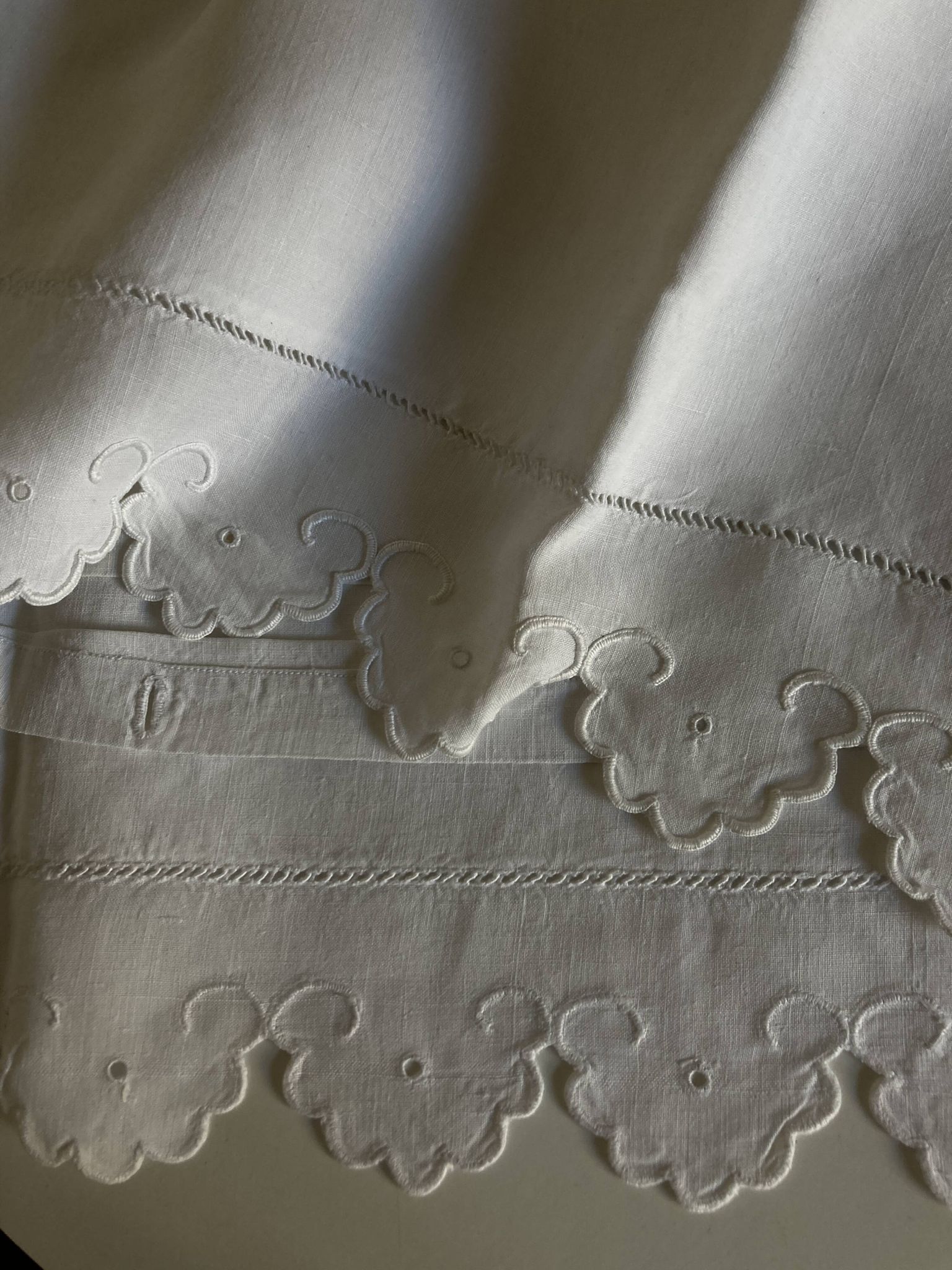 Pair of 19th-century linen pillowcases embroidered with scallops.