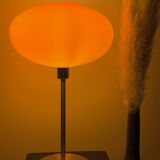 Table lamp with a vintage orange glass globe saucer and a gold base
