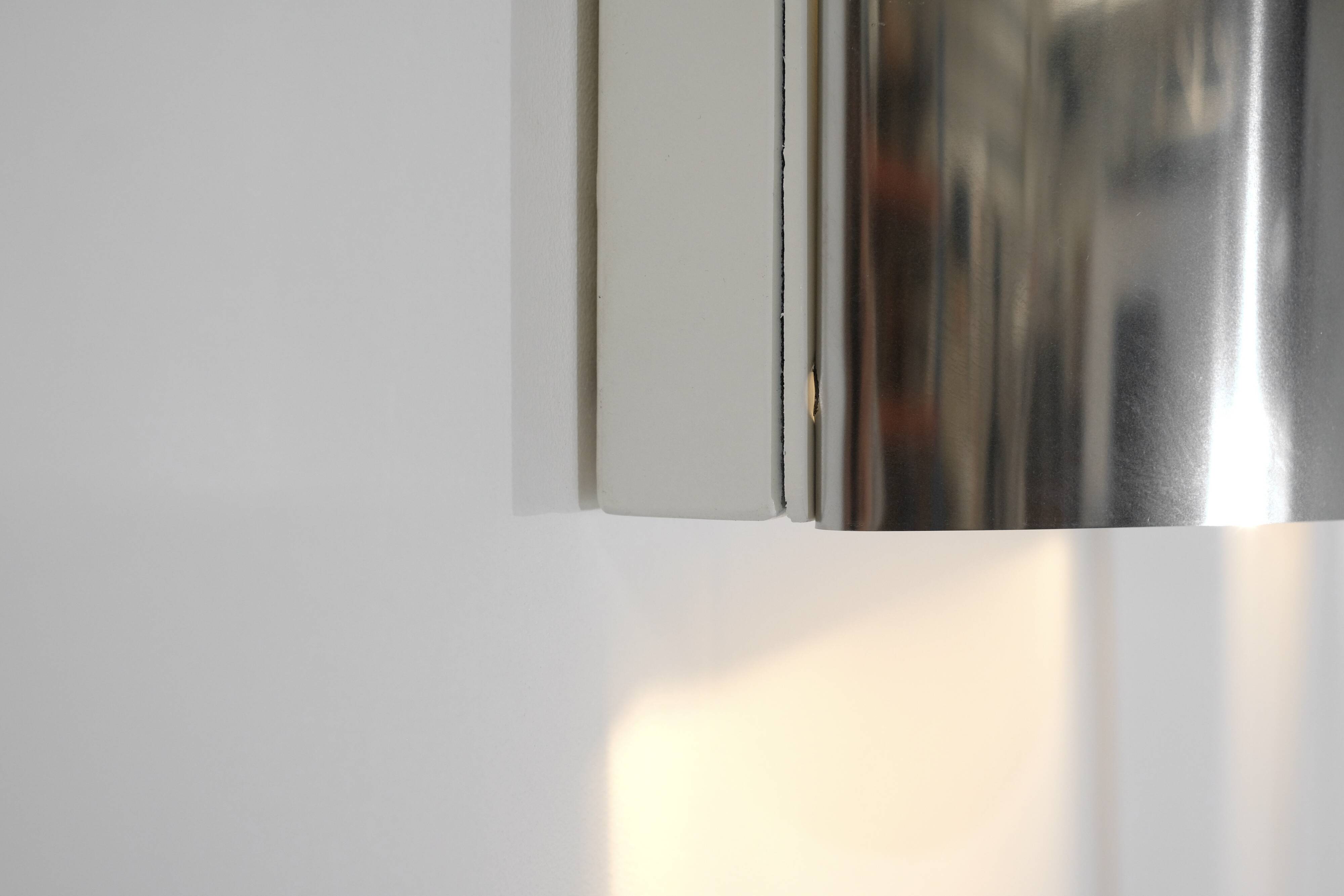 Contemporary wall light in stainless steel and metal.