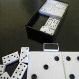 Complete set of miniature dominoes in black and white box.