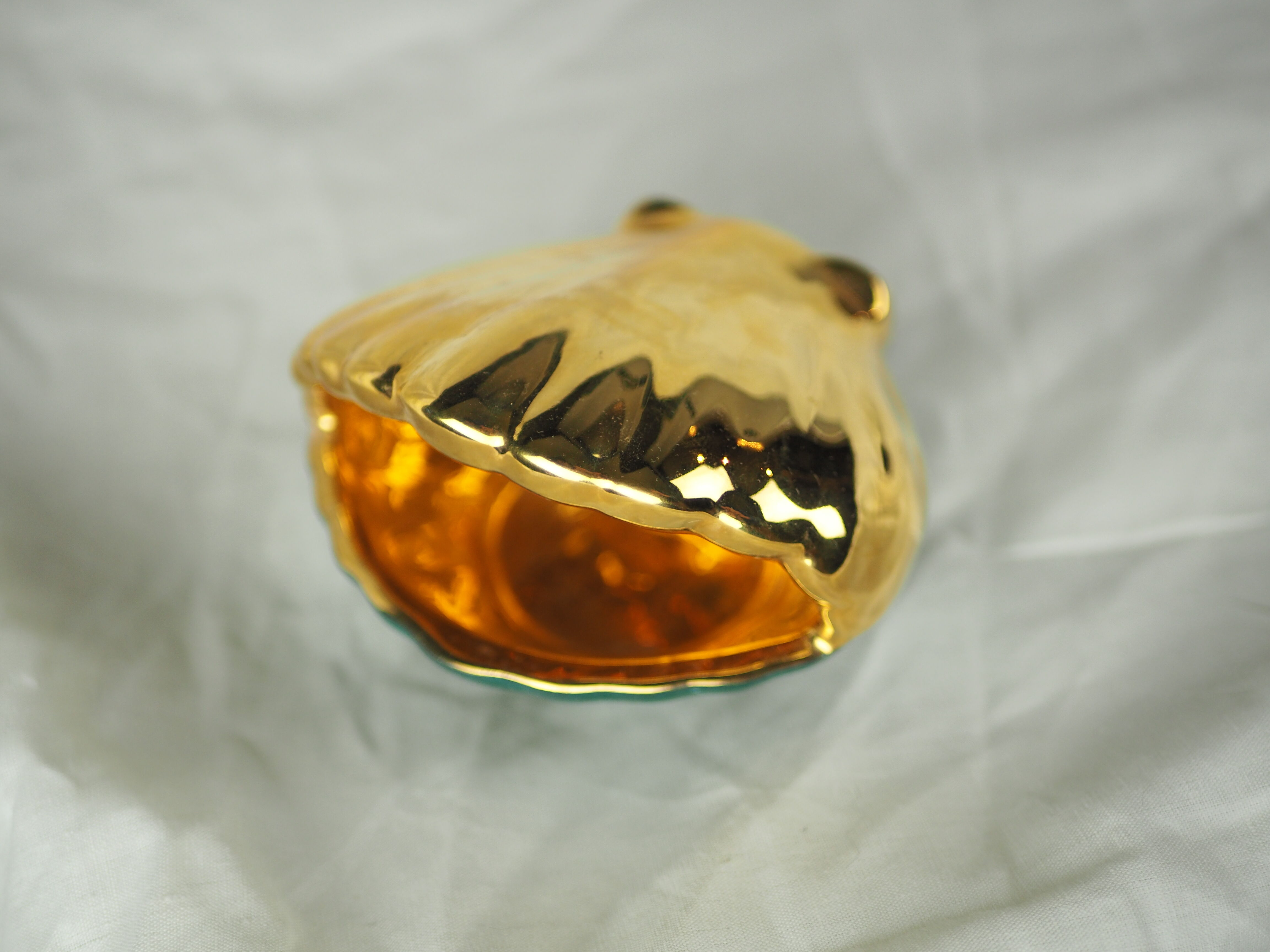Porcelain pocket tray in the shape of a golden scallop shell with duck green background from the 50s/60s