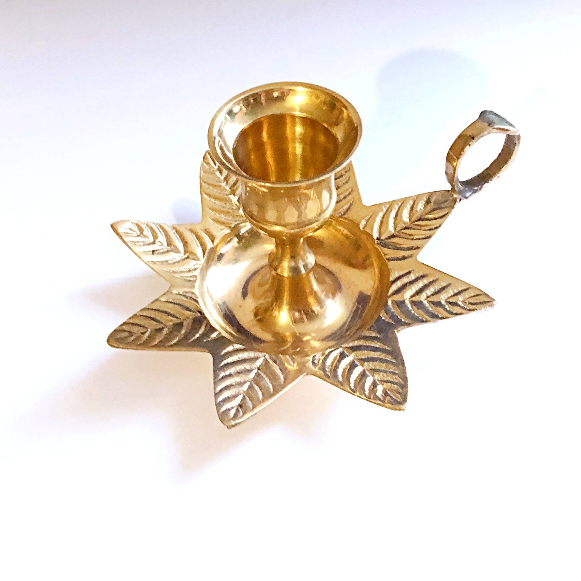 Golden brass hand candle holder decorated with leaves