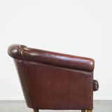Comfortable, rugged cognac-colored sheepskin club armchair with a characteristic seat cushion