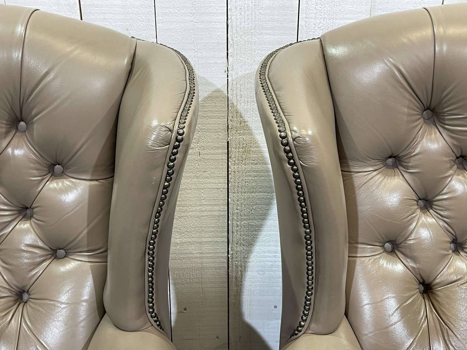 Pair of high-backed Chesterfield armchairs with 1 leather footrest
