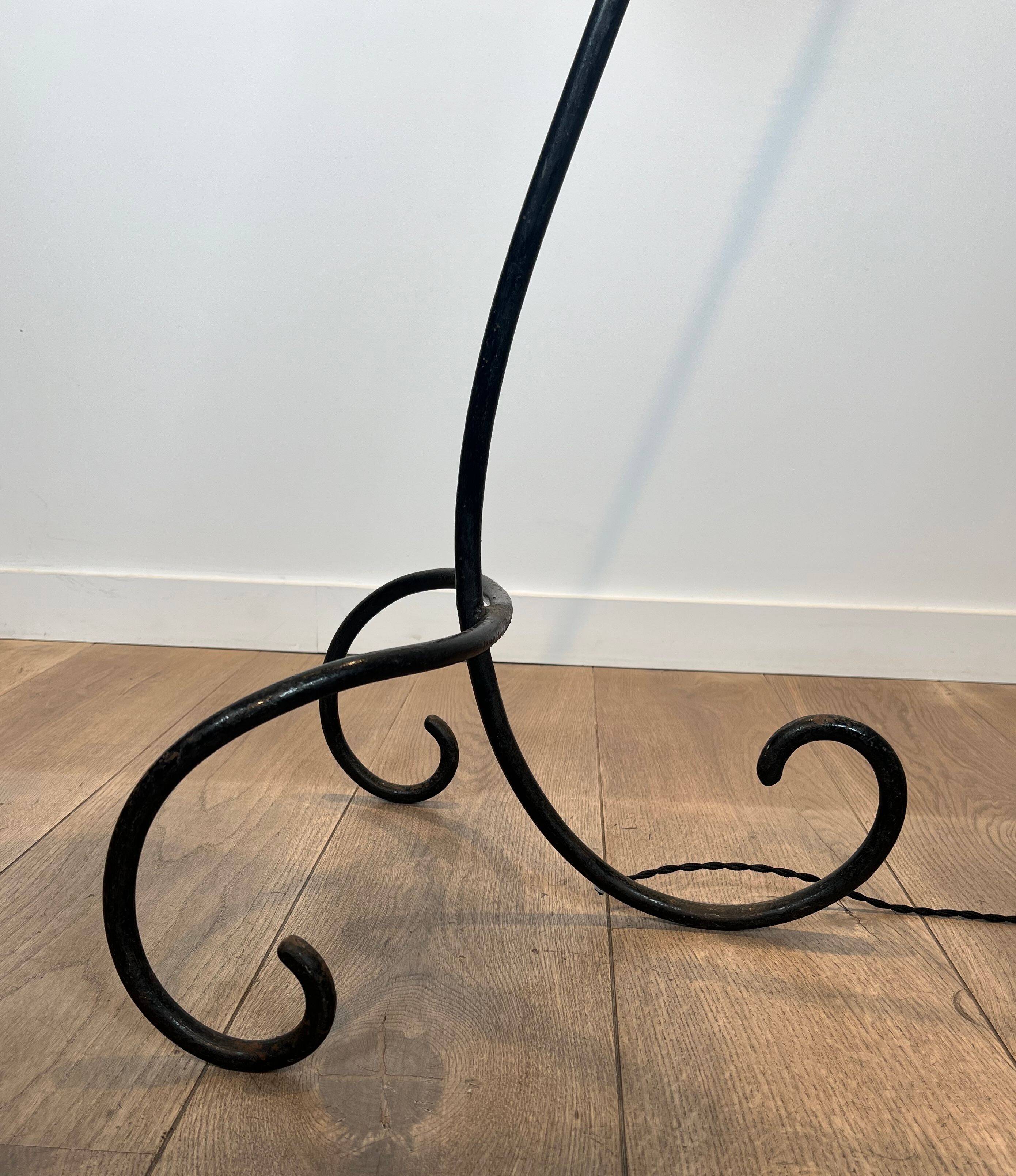Design floor lamp in black lacquered metal and brass.