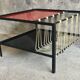 Modernist metal coffee table with a magazine rack in 1950s design.