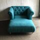 Mid-century turquoise blue fabric sofa with solid oak legs and tufting.
