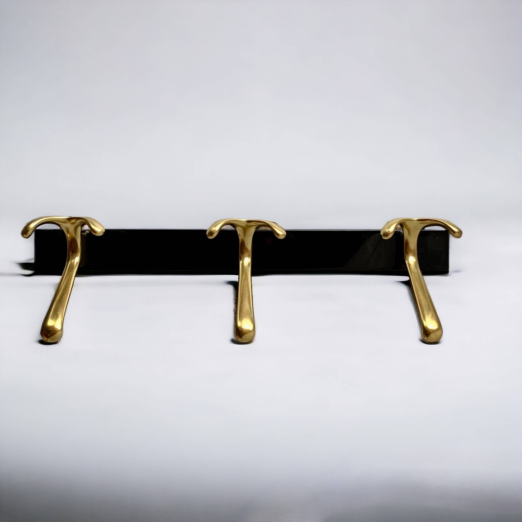 Vintage coat rack in lacquered metal with three golden aluminum hooks