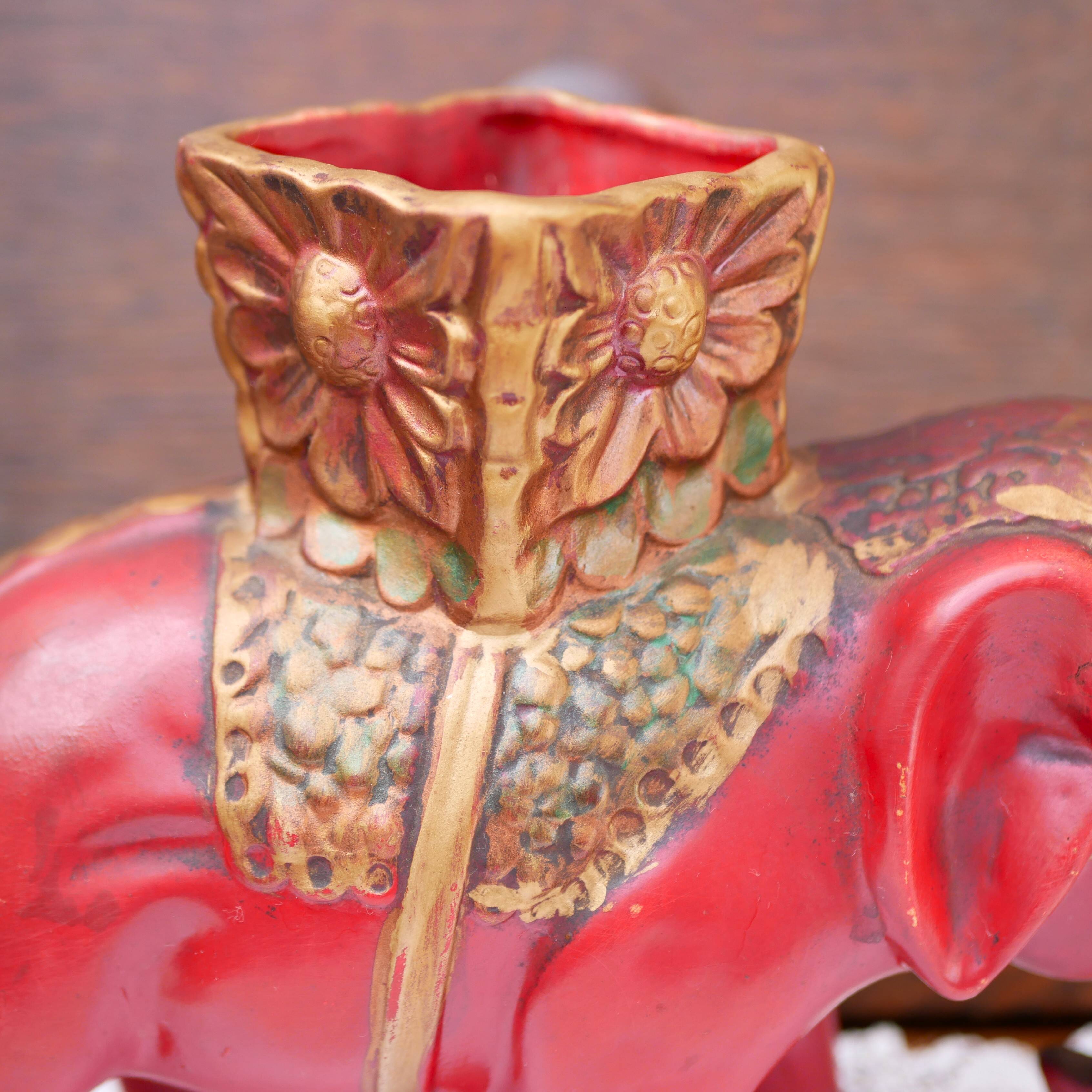 A pair of red and gold ceramic vases in the shape of elephants, 1940s.