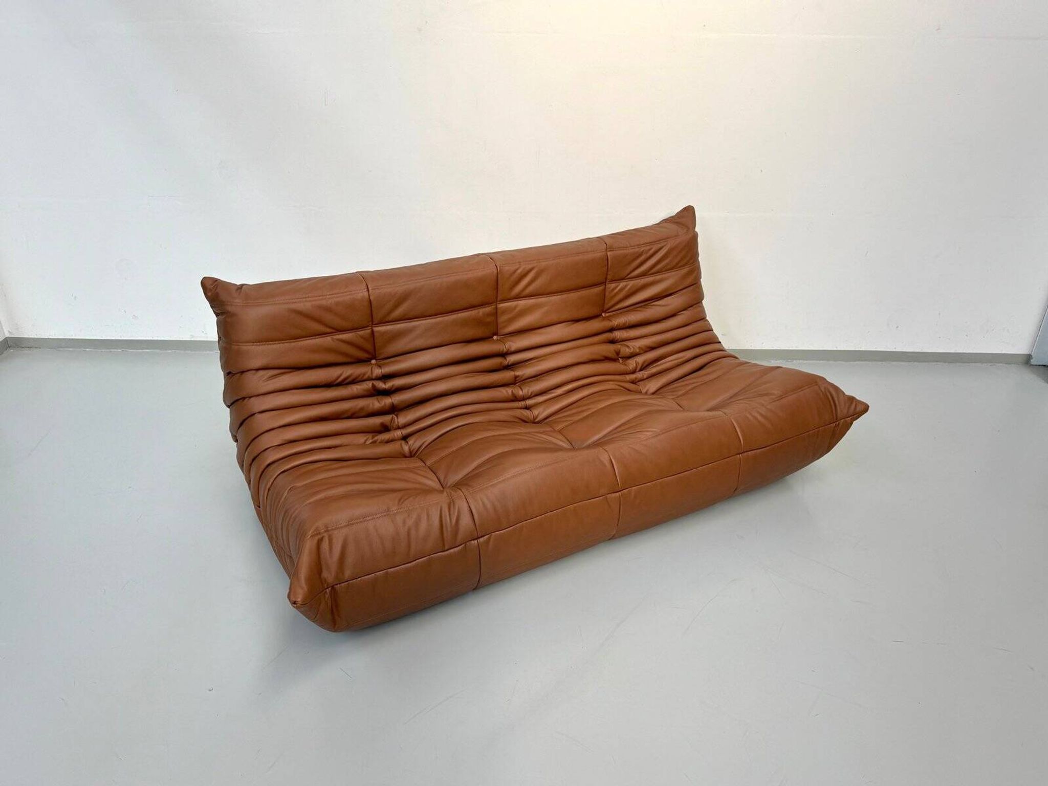 Three-seater Togo sofa in dark cognac leather by Michel Ducaroy for Ligne Roset.