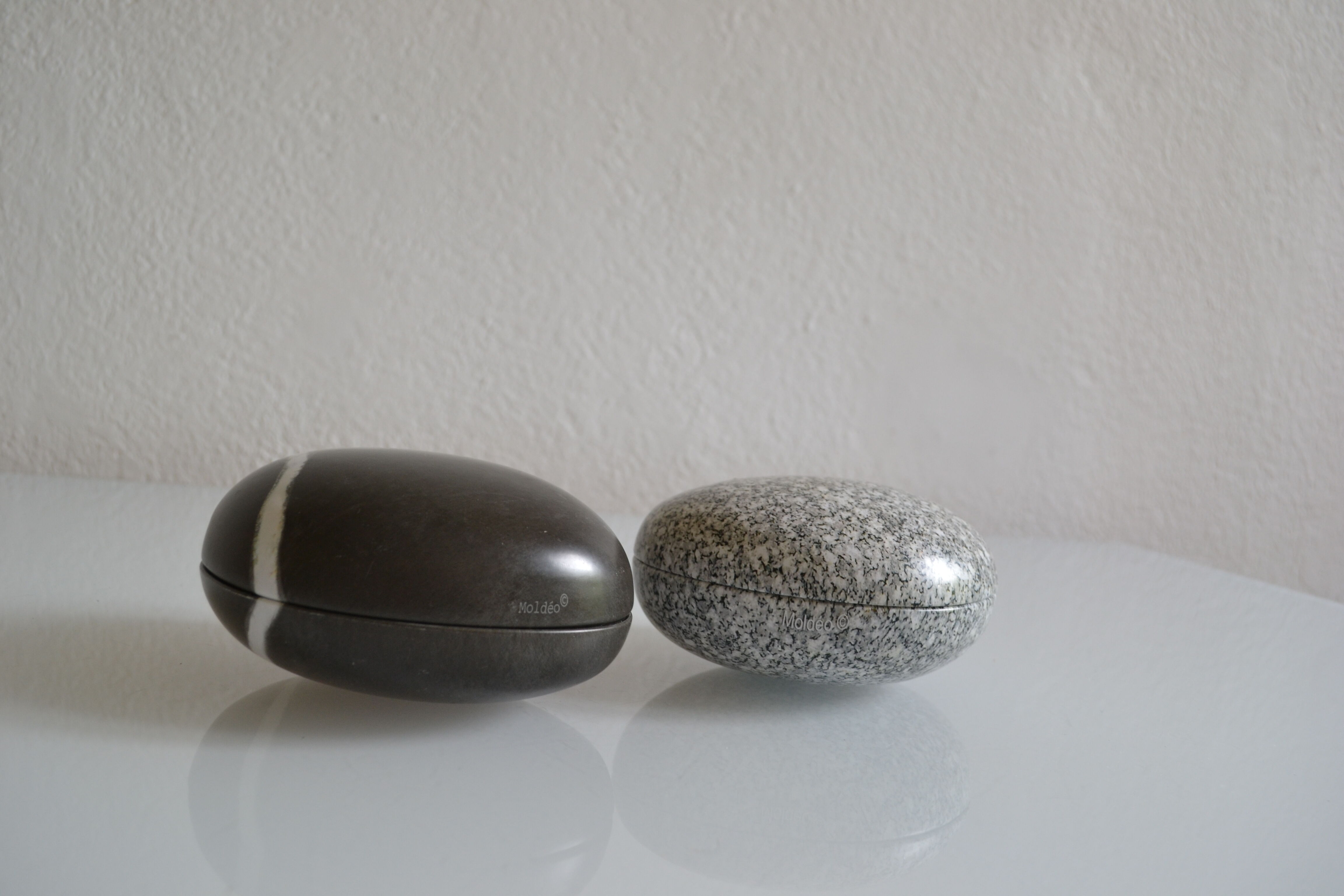 2 boxes in lithographed sheet metal in the shape of a pebble