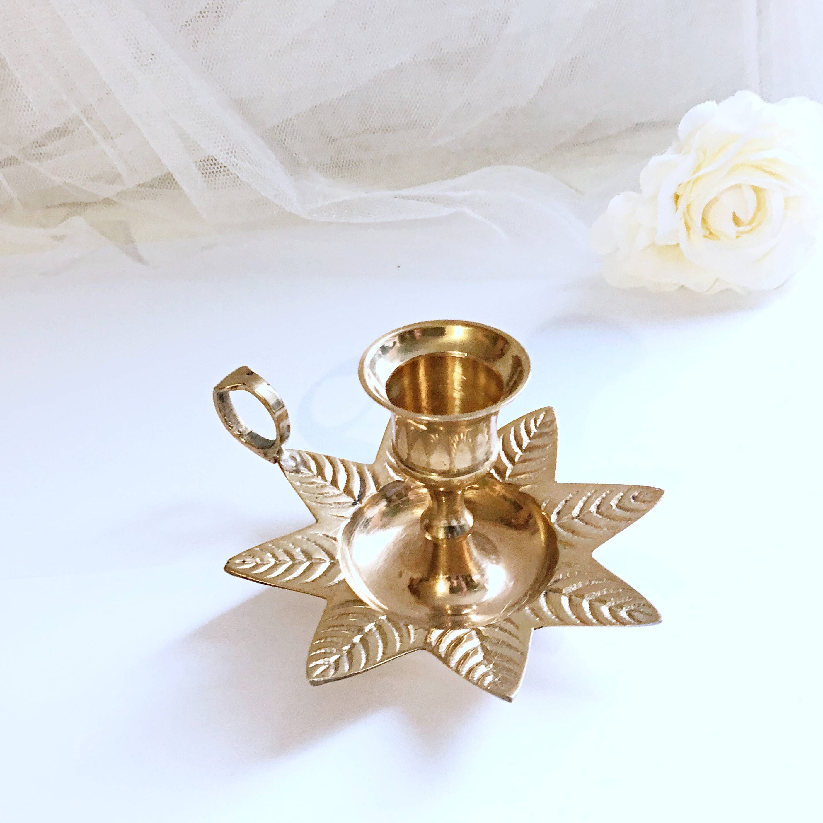 Golden brass hand candle holder decorated with leaves