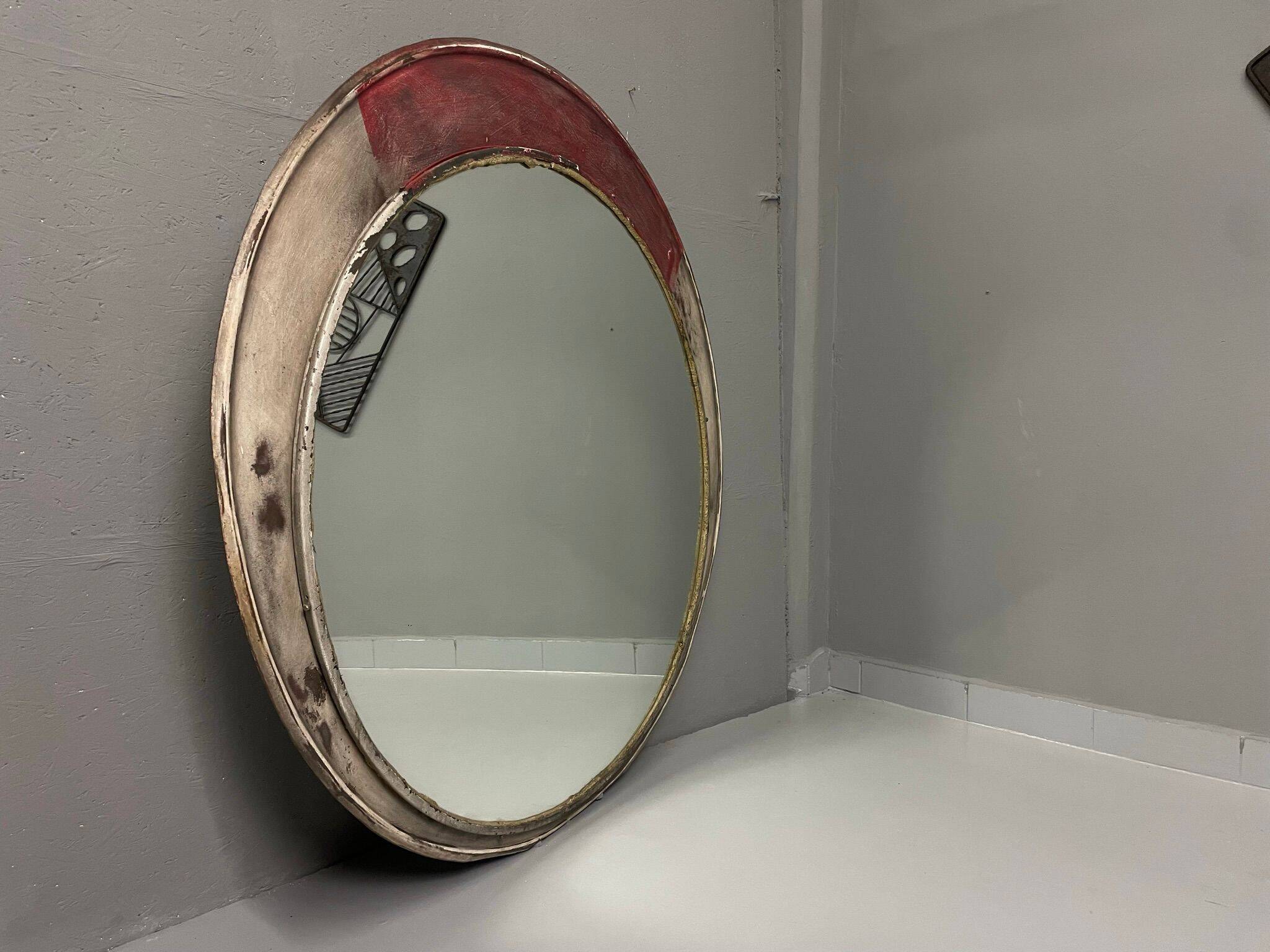 Vintage round mirror with an industrial metal frame in a painted finish.