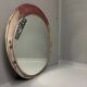 Vintage round mirror with an industrial metal frame in a painted finish.