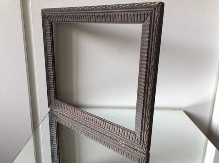 Antique wooden frame with geometric carvings light distress