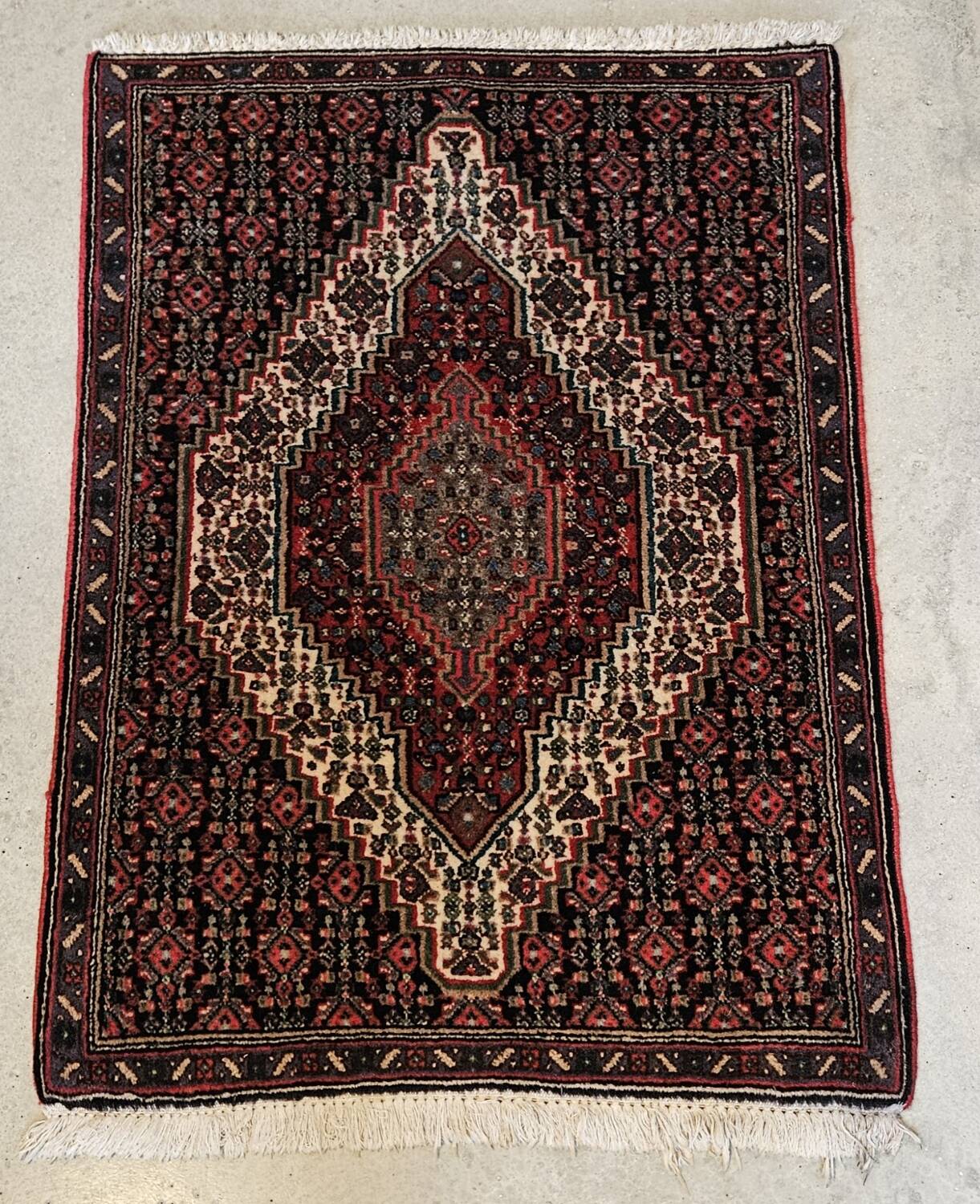 Ancient Persian carpet, wool, red tones, hand-knotted.