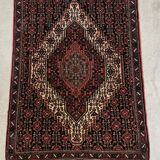 Ancient Persian carpet, wool, red tones, hand-knotted.