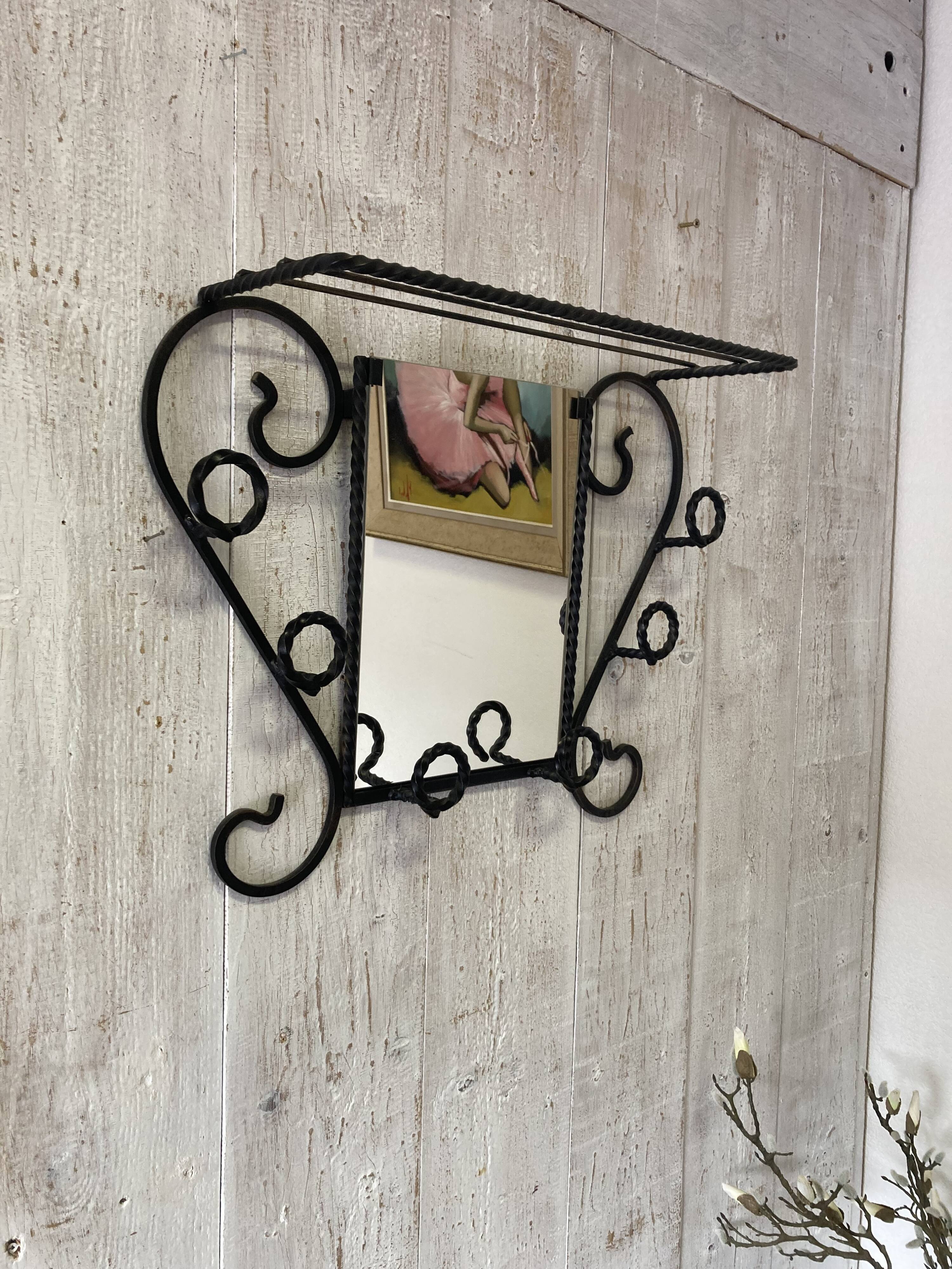 Wall-mounted coat rack with its mirror.