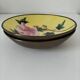 A pair of vintage Chinese decorative plates with floral designs on a yellow background.