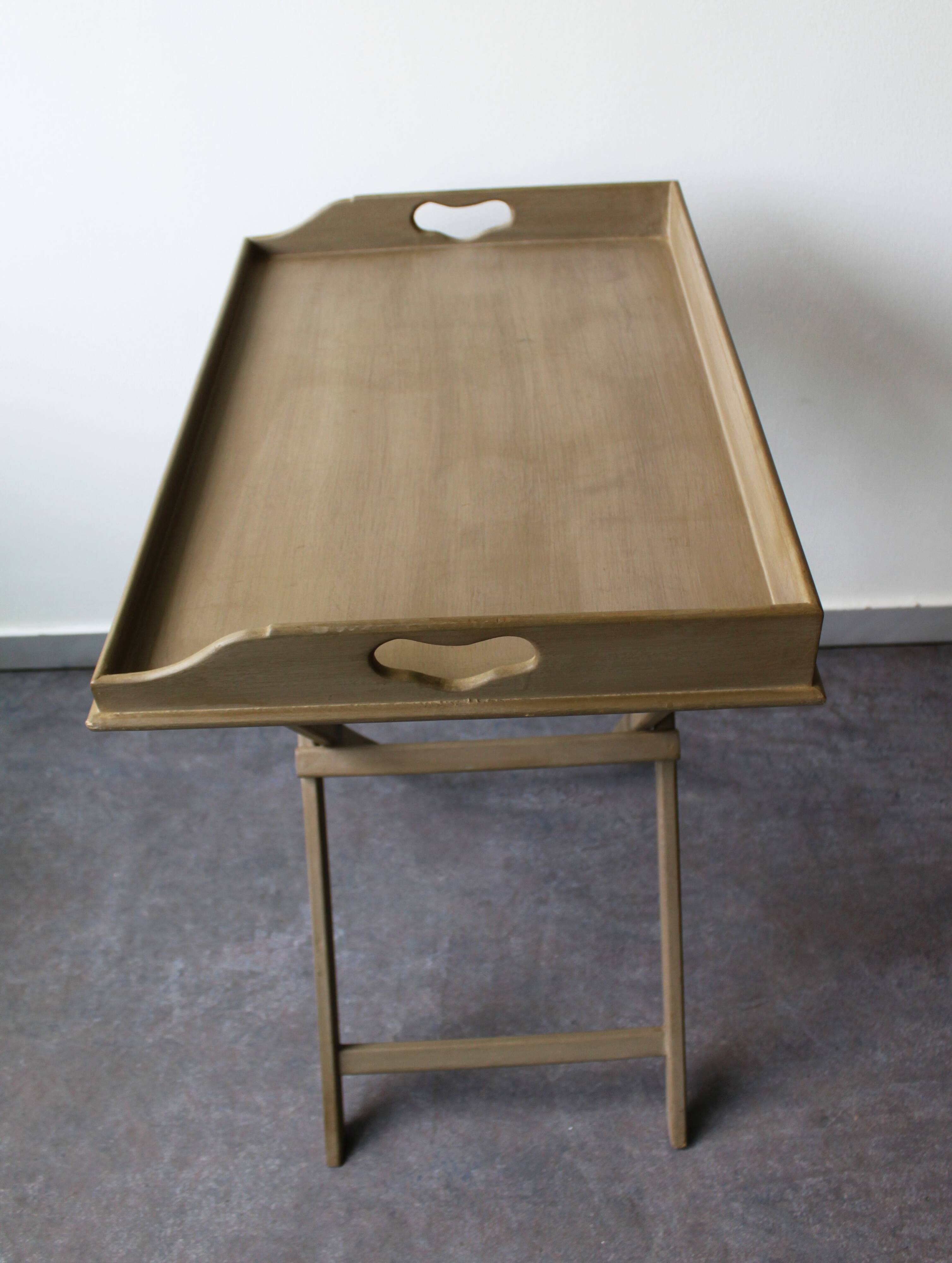 Folding and removable service tray in taupe-painted wood.