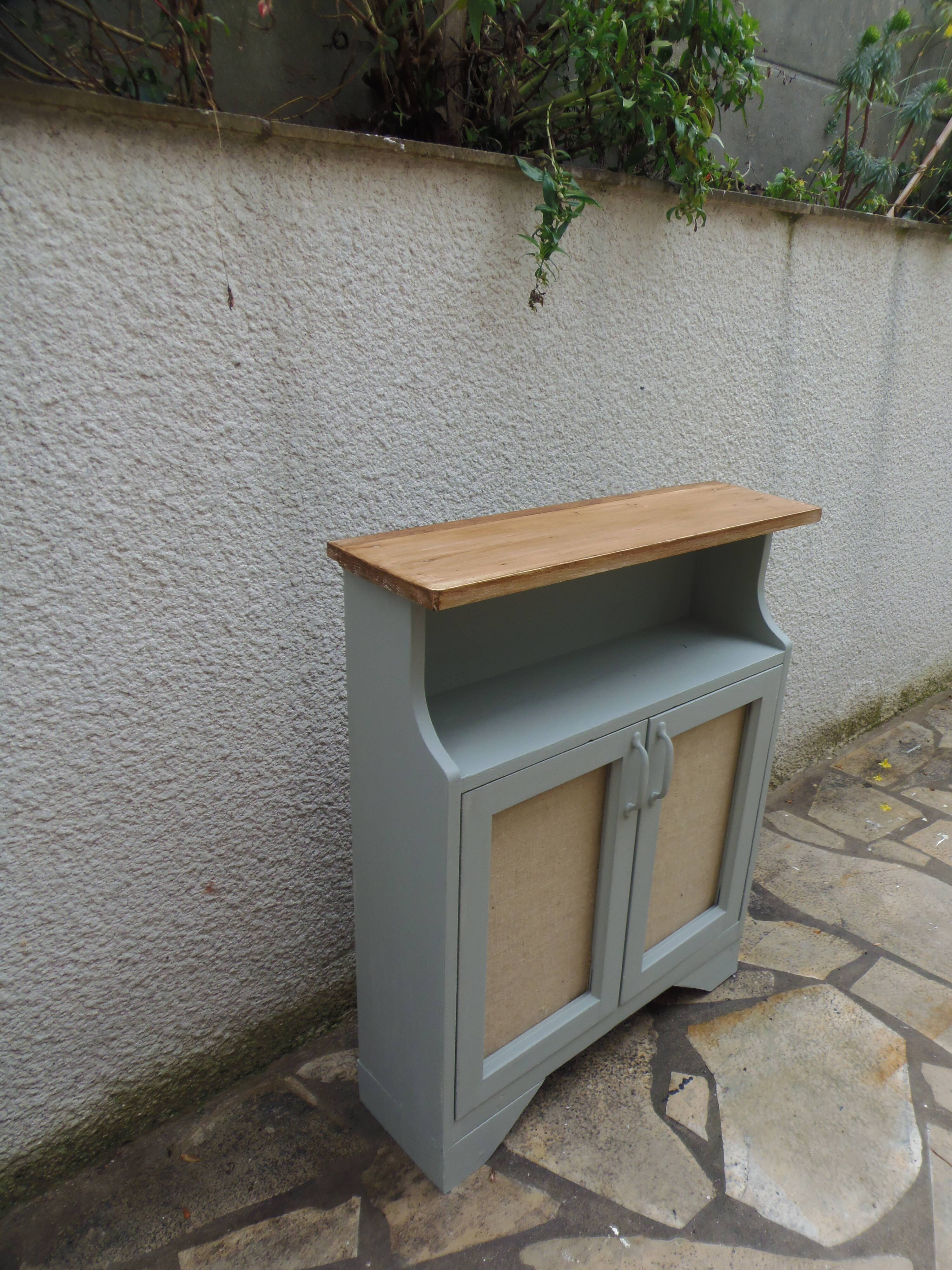 Small vintage green-grey piece of furniture, with 2 doors covered in burlap.