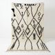 Moroccan Azilal rug with black patterns.