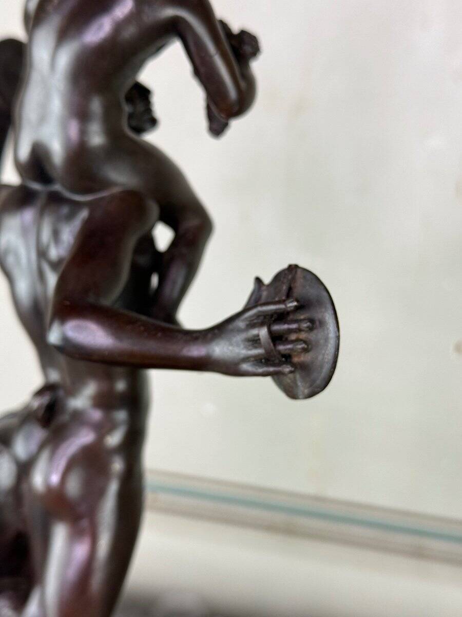 Dionysus on the shoulders of a satyr, bronze after the antique on a yellow Siena base.