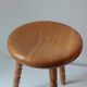 Vintage en bois tourné tabouret du milieu du siècle avec un siège épais.