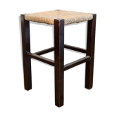 Vintage rustic stool in wood with a straw seat.