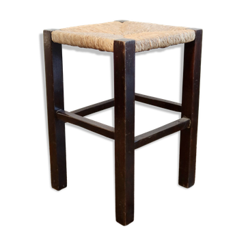 Vintage rustic stool in wood with a straw seat.