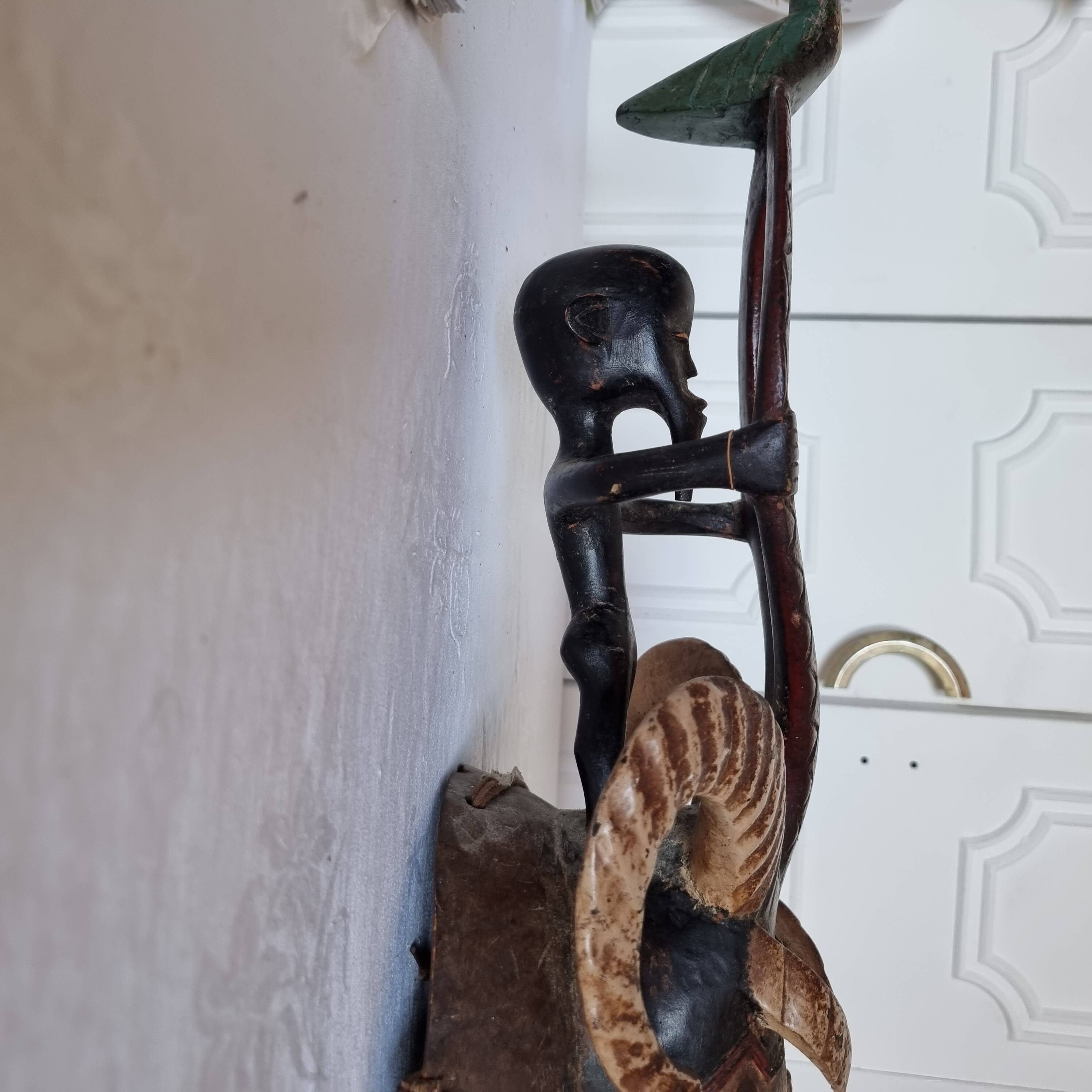 A large Senufo mask made of colored wood, decorated with an anthropomorphic figure