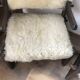 Set of 2 vintage wooden chairs with beige sheepskin seats, rustic style.