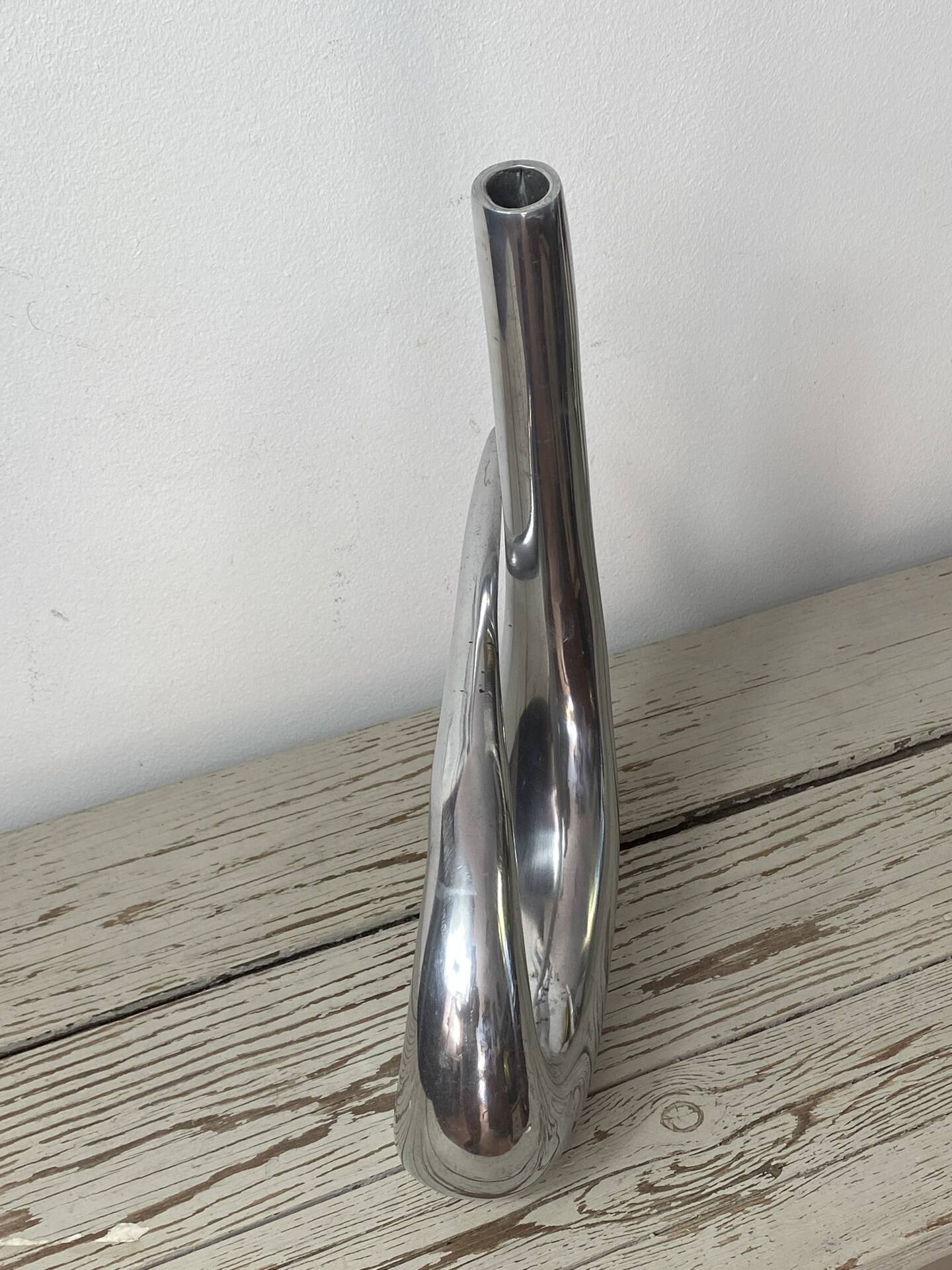 Sculptural vase design in polished aluminium.