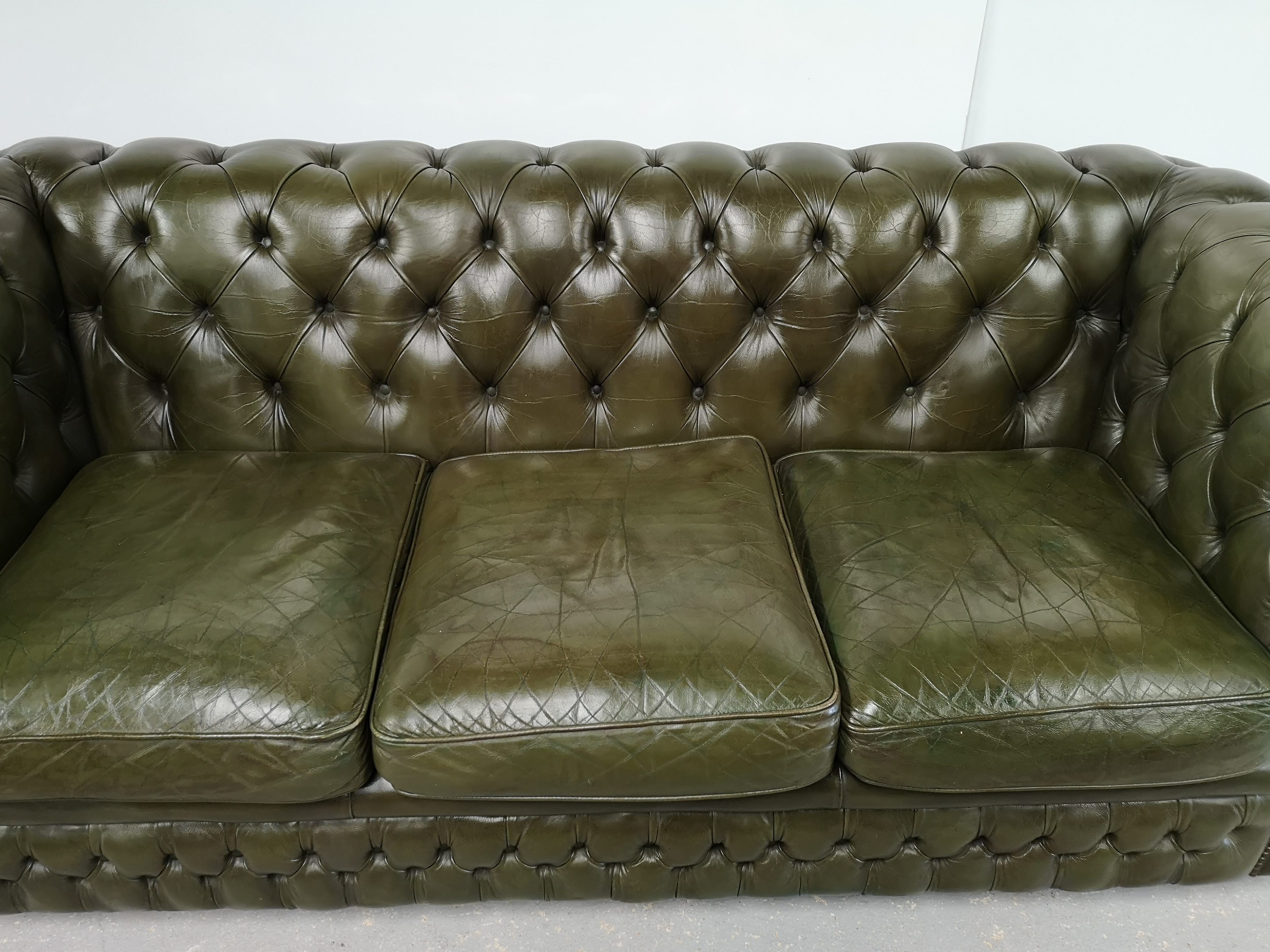 Three-seater green leather Chesterfield sofa