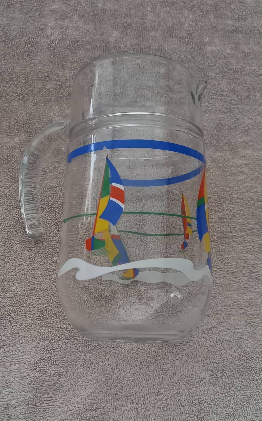 Vintage jug carafe for lemonade and juice, boats by the seaside, France.
