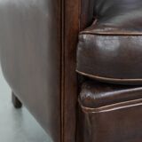 Dark brown vintage club armchair in English style made of sheepskin leather