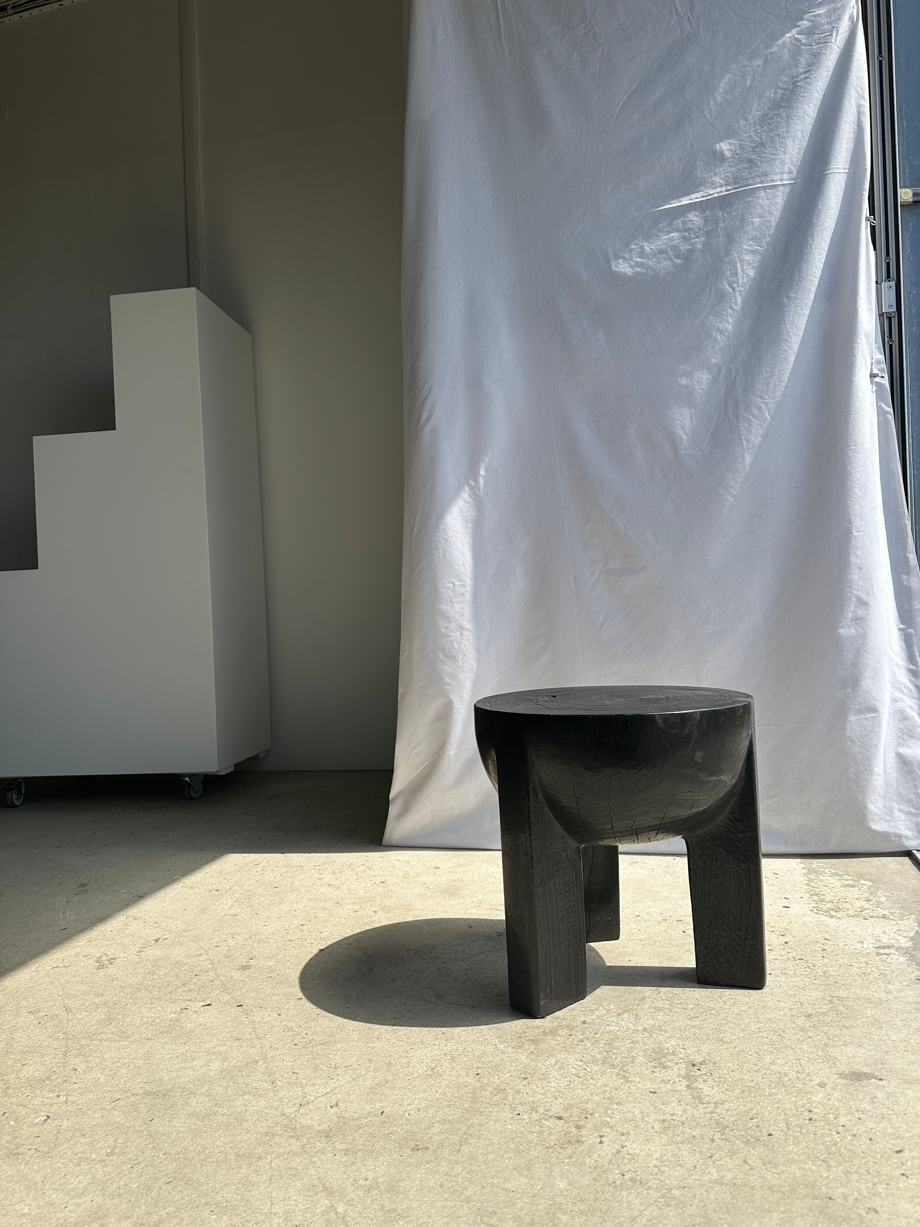 Black mango wood tripod side table with a semi-spherical top, height: 45 cm, diameter: 44 cm.