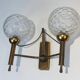 Pair of brass wall lights with glass globes. Around 1970.