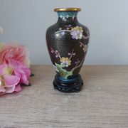 Small black cloisonné vase decorated with yellow and pink cherry blossoms, vase on wooden base