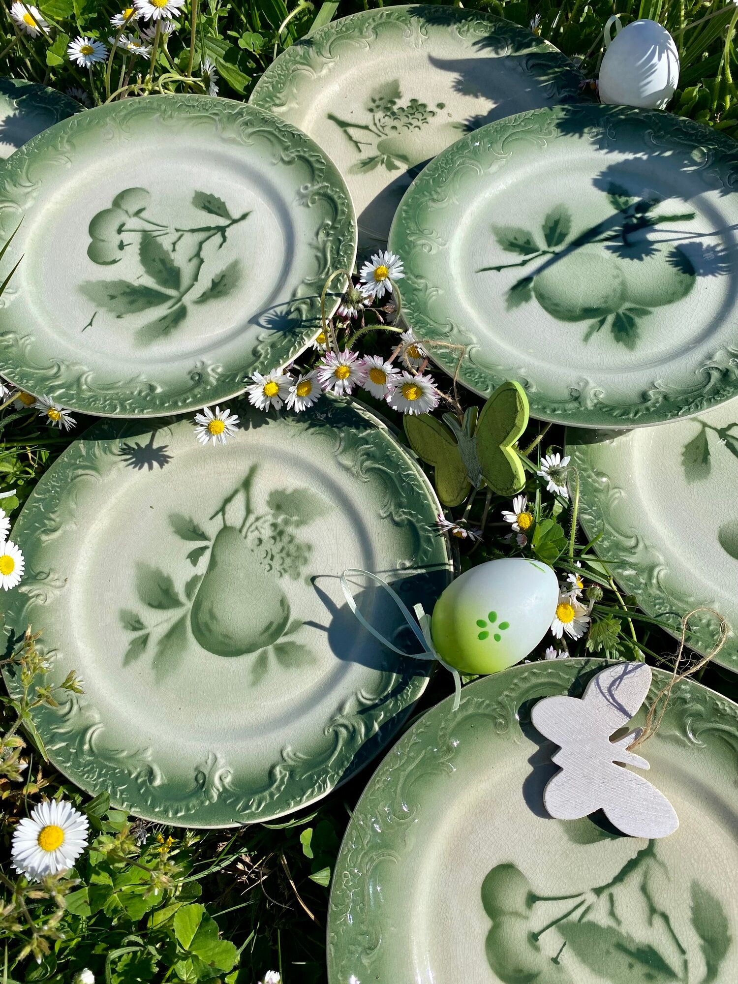 11 old dessert plates from the Pexonne earthenware factory, green and cream fruit decoration