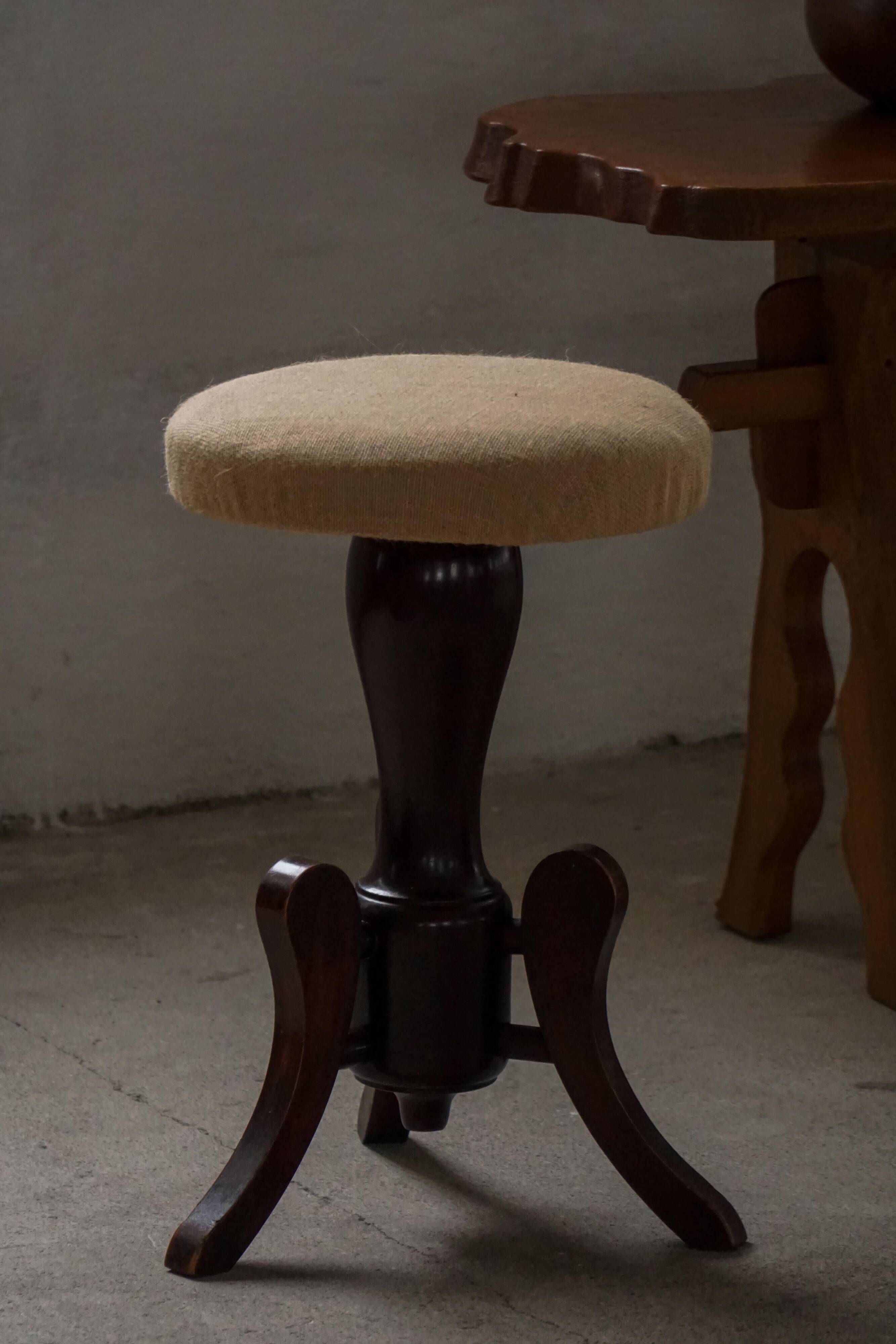 Adjustable Victorian-style piano stool with a jute fabric seat, early 20th century.