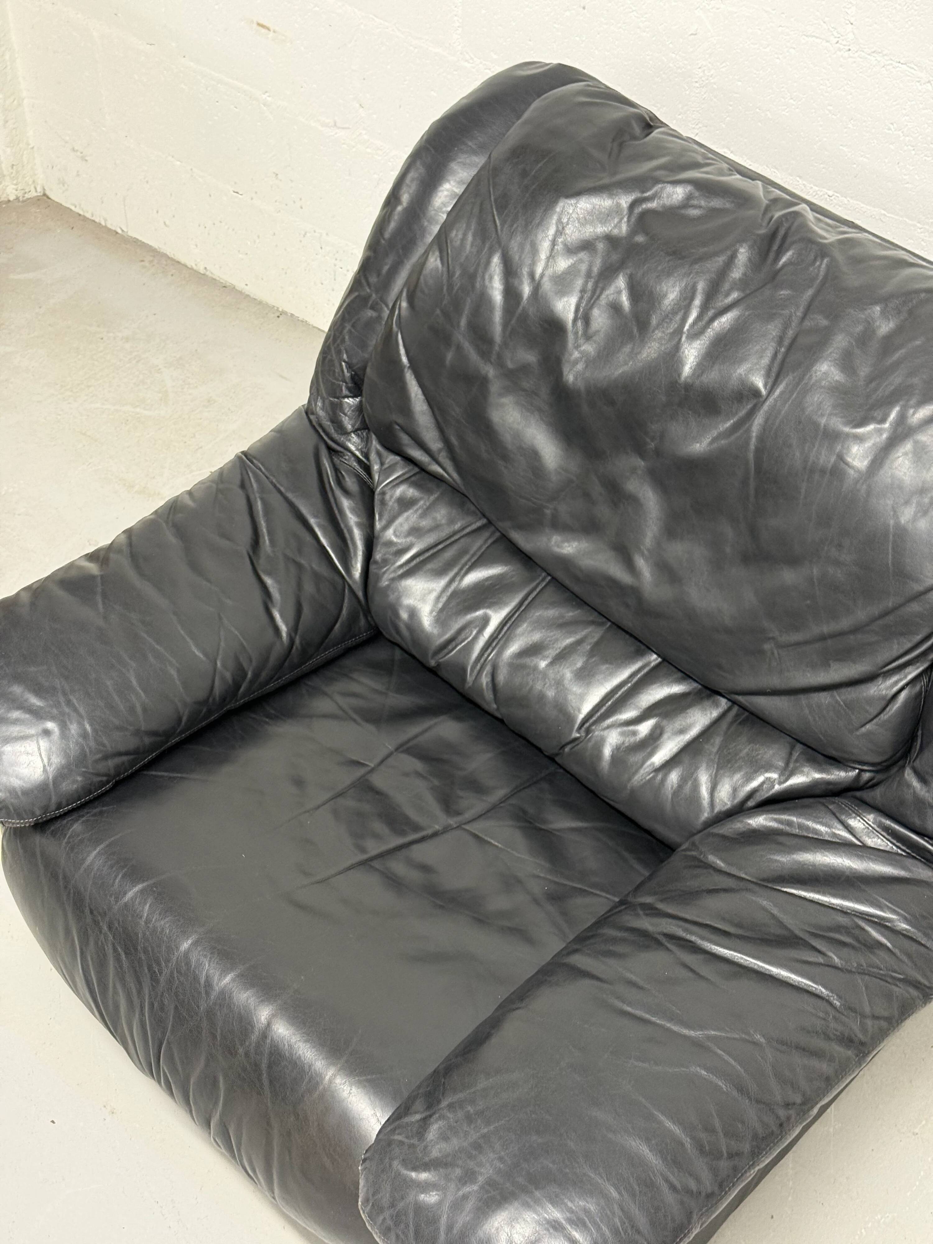 Vintage black leather lounge chair — low postmodern club chair from the space age.