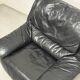 Vintage black leather lounge chair — low postmodern club chair from the space age.