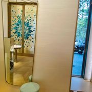Rectangular mirror with rounded edges and a repoussé brass frame.