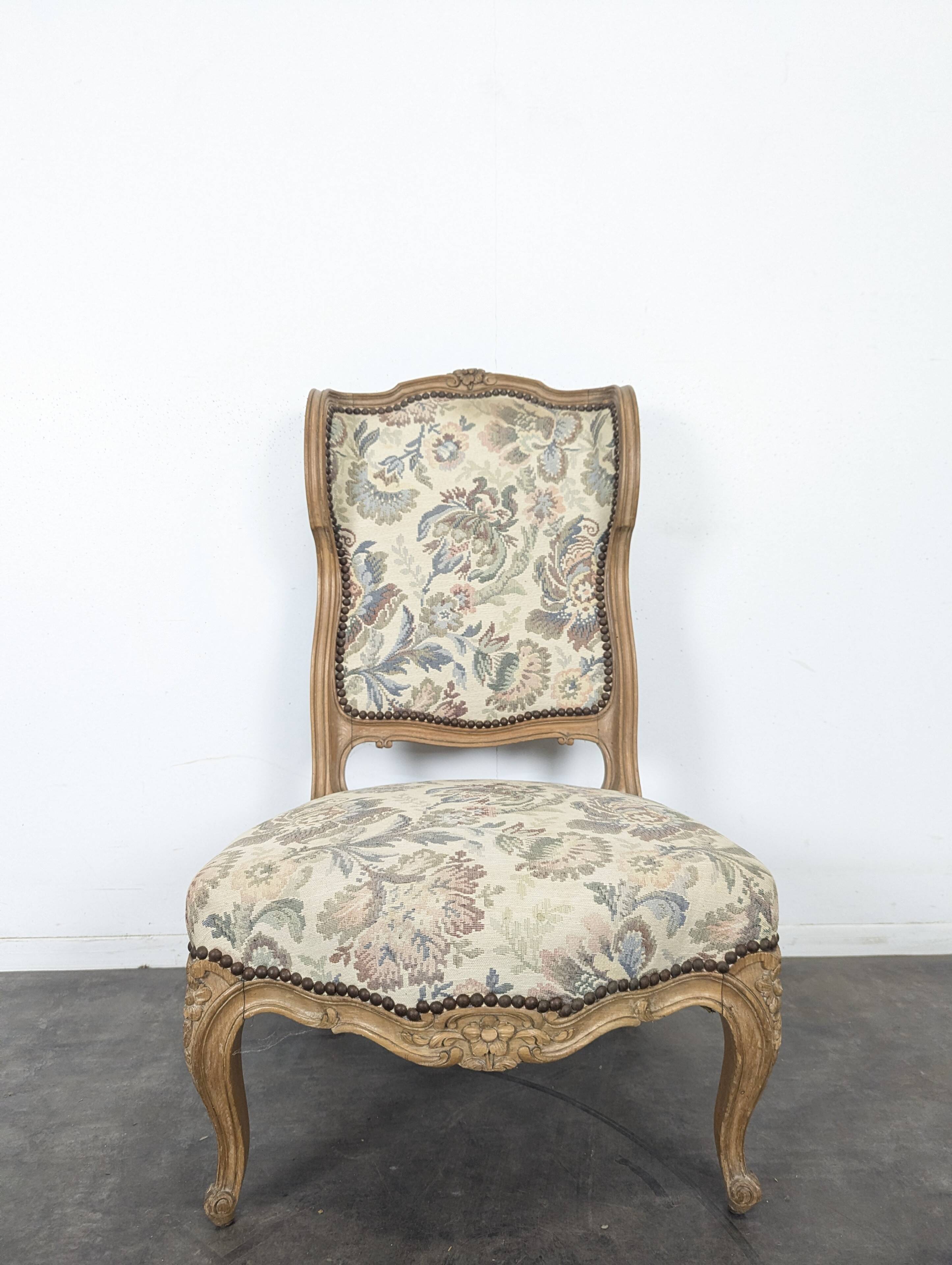 Louis XV style armchair in natural wood with floral fabric.
