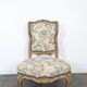 Louis XV style armchair in natural wood with floral fabric.