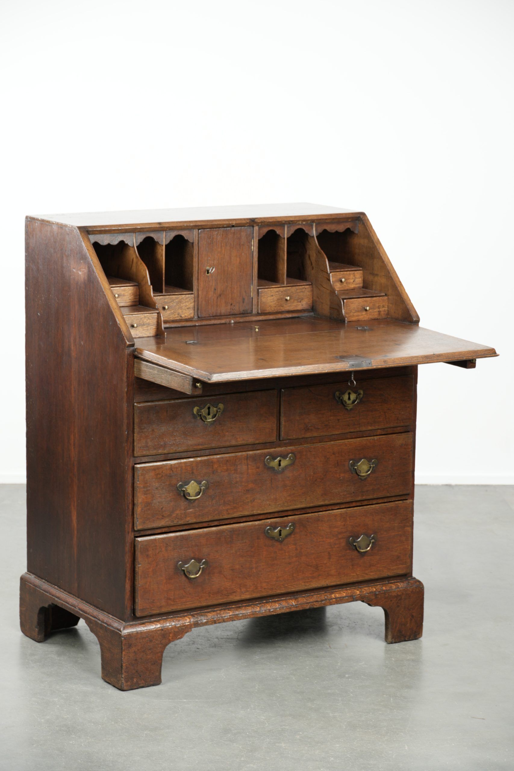 Antique English oak secretary from the 18th century with a stepped interior